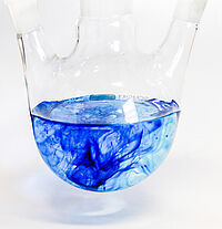 Three neck flask containing a few drops of methylene blue in water
